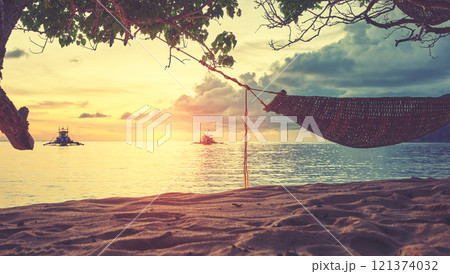 Hammock on the beach of a small island in the Philippines at sunset, color toning applied. Hammock on the beach of a small island in the Philippines at sunset, color toning applied. 121374032