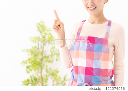 エプロン姿で指差しポーズの女性イメージ　(写真素材) 121374056