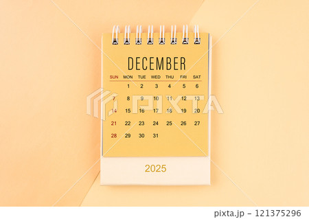 December 2025 mini desk calendar on the yellow, planning for business meeting. 121375296