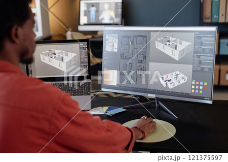 Person analyzing architectural designs on computer screens at office workspace, focusing on detailed models and layouts for a project. Engaging in work through high-end technology 121375597