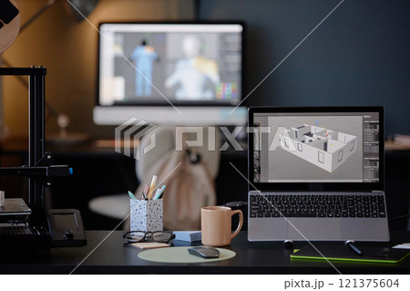 Office desk setup with laptop showing architectural designs and screens in background depicting digital modeling creating focused atmosphere enhancing productivity 121375604