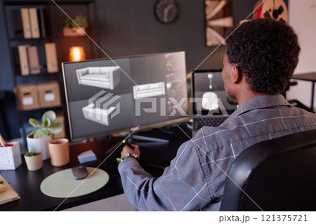 Designer working on detailed virtual models of contemporary furniture in home office setup. Display shows 3D renderings of sofa, showcasing intricate design process Designer working on detailed virtual models of contemporary furniture in home office setup. Display shows 3D renderings of sofa, showcasing intricate design process 121375721