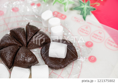 クッキー生地でマシュマロを包んでいく 121375802