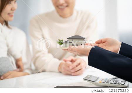 家の模型で設計の話をするビジネスウーマン 121375829