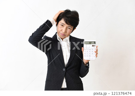 電卓を持ち困るスーツ姿の中高年の女性 121376474