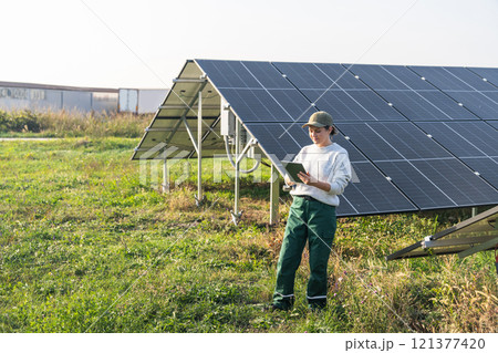 Female farmer with digital tablet on a modern farm using solar panels Female farmer with digital tablet on a modern farm using solar panels 121377420