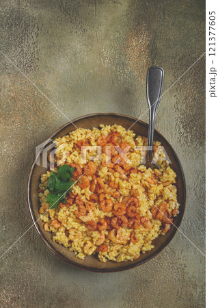 risotto with shrimp, in a bowl, on a textured surface, with a side dish of fresh coriander, homemade, no people, 121377605
