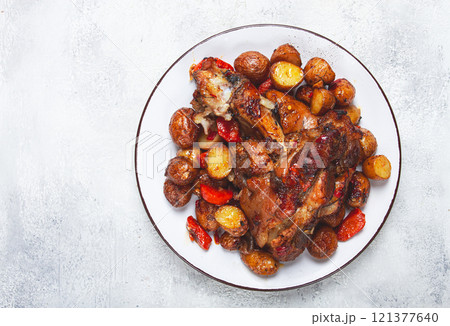 Pork knuckle baked with vegetables, new potatoes , on a white plate, homemade, no people, 121377640