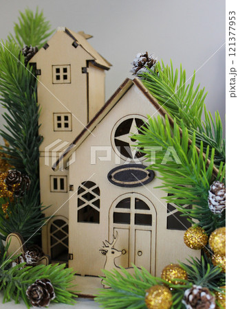 Porch of a wooden toy house made from a construction set with a plywood cut out reindeer and Christmas decorations. Craft house model and New Year spirit  121377953