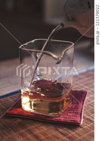 An Elegant and Refined Pour of Rich Whiskey into a Glass, Resting on a Colorful Coaster 121378022
