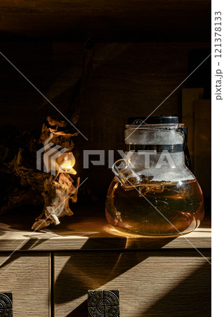 An Artistic Glass Jar filled with Liquid beautifully placed on a Wooden Shelf for display An Artistic Glass Jar filled with Liquid beautifully placed on a Wooden Shelf for display 121378133
