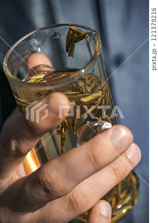 Holding a Beautiful Glass of Herbal Tea Made with Natural Ingredients and Flavors 121378216