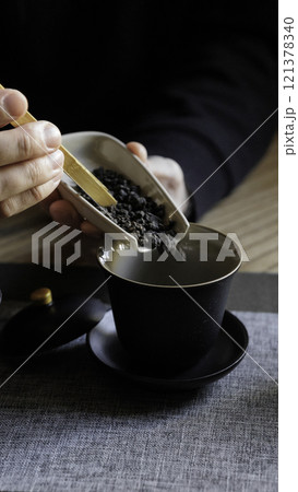 Experience the elegance of tea preparation using your hands along with a beautiful black tea cup Experience the elegance of tea preparation using your hands along with a beautiful black tea cup 121378340