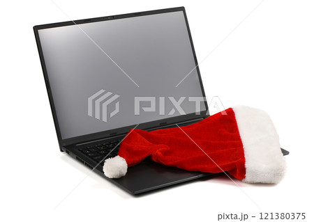 Laptop or notebook with blank screen, on the screen red santa claus hat isolated on transparent background. 121380375
