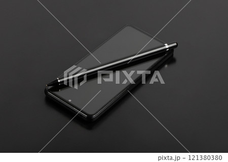 Stylus for drawing on capacitive screens. The stylus lies on the smartphone screen on a black background. 121380380