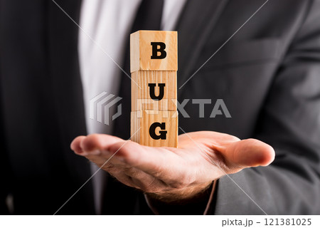 Businessman holding wooden blocks with the word Bug 121381025