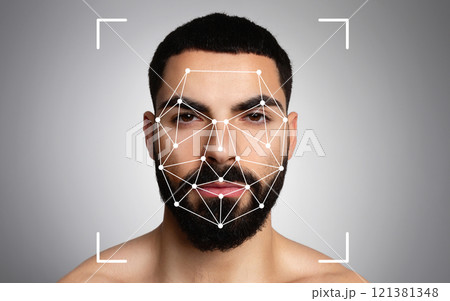 Middle eastern man is undergoing facial recognition analysis, with pattern mapping visible on his face against a neutral background. Middle eastern man is undergoing facial recognition analysis, with pattern mapping visible on his face against a neutral background. 121381348