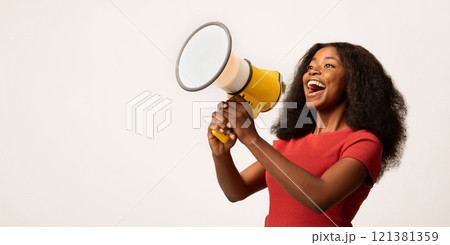 Great Promo. Excited Black Lady Using Megaphone For Making Announcement, Cheerful African American Woman Holding Loudspeaker, Sharing News While Standing On White Background, Panorama, Copy space 121381359
