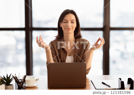 Mental Hygiene. Calm beautiful girl meditating at workplace, dealing with stress and anxiety. Empty space Mental Hygiene. Calm beautiful girl meditating at workplace, dealing with stress and anxiety. Empty space 121381596