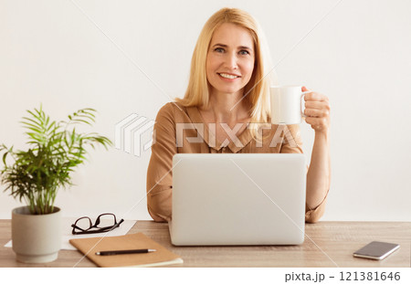 Freelance Work. Smiling Woman Working And Drinking Coffee At Home Office Freelance Work. Smiling Woman Working And Drinking Coffee At Home Office 121381646