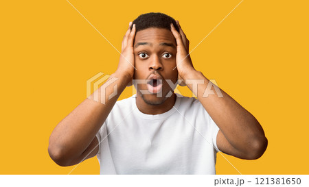 Oh No. Scared black guy clasping his head with open mouth isolated over orange studio wall, copyspace, panorama 121381650