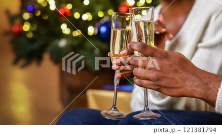 Cheers. African american couple clinking champagne glasses celebrating Christmas or New Year Eve together, toasting holidays, closeup Cheers. African american couple clinking champagne glasses celebrating Christmas or New Year Eve together, toasting holidays, closeup 121381794