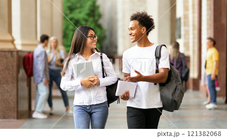 College friends walking in campus and talking, having break after classes 121382068