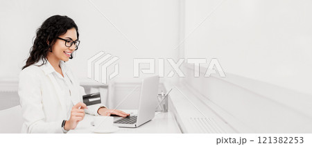 Investment Concept. Happy mexican businesswoman showing credit card, making donation using laptop, copyspace 121382253