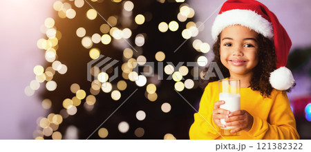 Cute little african american girl drinking milk in Santa hat in Christmas Eve, free space Cute little african american girl drinking milk in Santa hat in Christmas Eve, free space 121382322