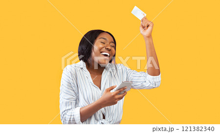 Mobile Banking. Joyful African American Girl Holding Smartphone And Credit Card Dancing Over Pink Studio Background. Panorama Mobile Banking. Joyful African American Girl Holding Smartphone And Credit Card Dancing Over Pink Studio Background. Panorama 121382340