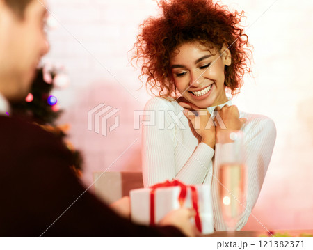 Merry Christmas. Boyfriend Giving Xmas Gift Congratulating Girlfriend Celebrating New Year Indoors. Selective Focus 121382371
