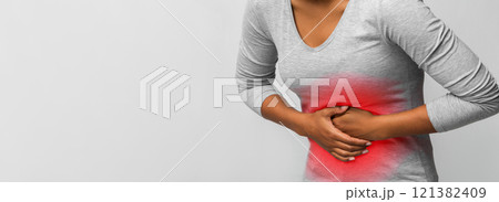 Food poisoning. Cropped of black woman with abdominal pain, suffering from diarrhea, photo with red sore zone Food poisoning. Cropped of black woman with abdominal pain, suffering from diarrhea, photo with red sore zone 121382409