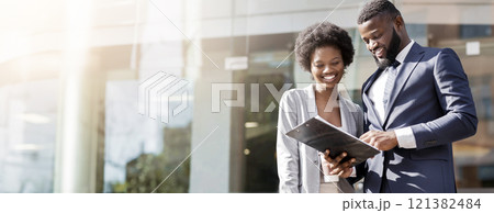 Happy couple of african american business partners working while standing outdoors, discussing new project. Blurred background with copy space 121382484