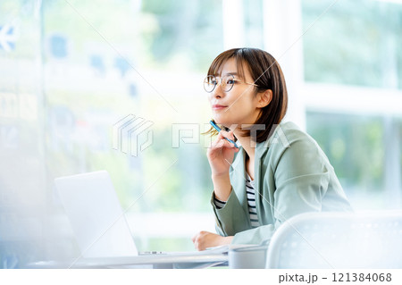 パソコンで仕事をする女性　カフェで仕事中の女性 121384068