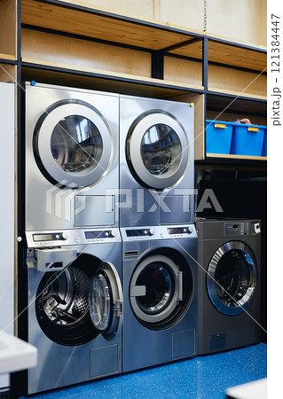 Vertical shot of professional washing machines with open drawers for detergents and softeners at self service laundry, copy space 121384447