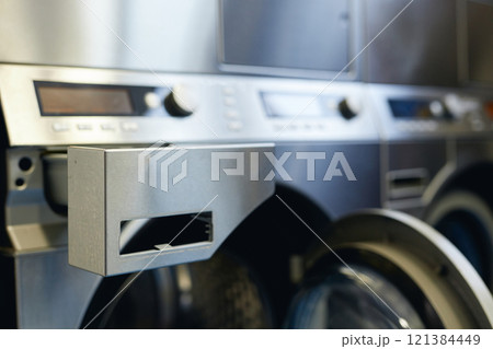 Close up on washing machine dispenser drawer for clothes softener and detergent in self service laundry, copy space 121384449