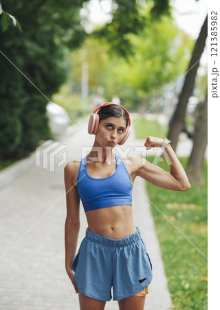 An Empowered Young Woman Dressed in Trendy Sportswear Enjoying Outdoor Fitness Activities 121385982