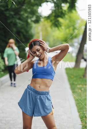 An Energetic Young Woman Enthusiastically Enjoying Her Thrilling Outdoor Workout Session An Energetic Young Woman Enthusiastically Enjoying Her Thrilling Outdoor Workout Session 121385983
