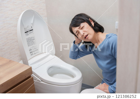 トイレのトラブルに悩むミドル女性 121386252