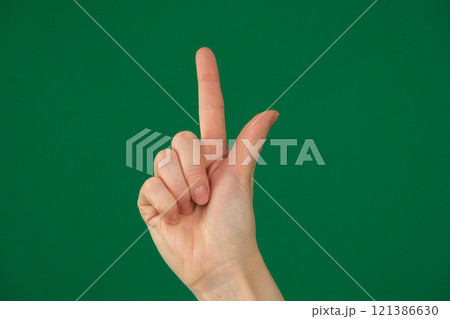 pointing at something with your index finger. isolated green background 121386630