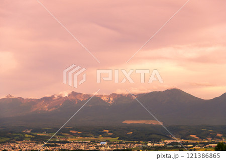 【上富良野町　千望峠からの秋の夕暮れと十勝岳連峰】 121386865