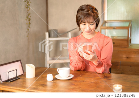 カフェでスマホを使う女性　 121388249