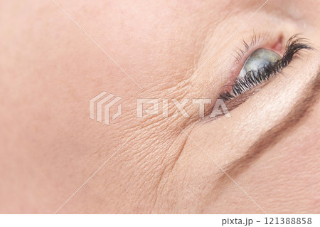 Close up of caucasian female mature eye with detailed wrinkles and expression Close up of caucasian female mature eye with detailed wrinkles and expression 121388858