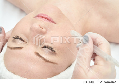 Caucasian female receiving skincare treatment with microdermabrasion for smooth Caucasian female receiving skincare treatment with microdermabrasion for smooth 121388862