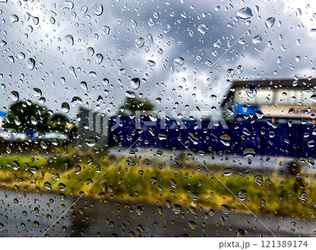 Raindrops covering a window create a picturesque scene Raindrops covering a window create a picturesque scene 121389174