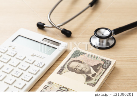机に置かれた聴診器と100万円 121390201
