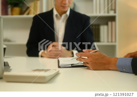 Businessman reviewing and signing formal agreement under the guidance of lawyer 121391027