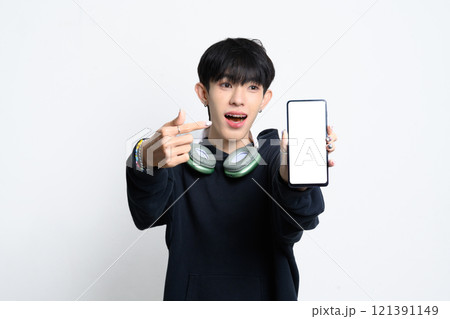 Cute young asian man in hoodie excitedly pointing at smartphone with a blank screen 121391149
