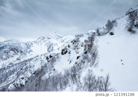 High mountain peaks covered with snow on a winter cloudy day 121391186