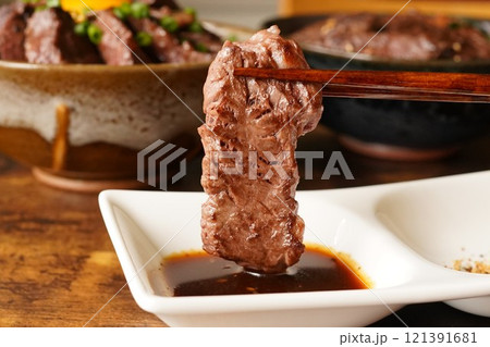 たっぷりのタレにつけた牛ハラミの焼肉 121391681